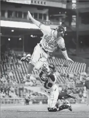  ?? Peter Diana/post-gazette photos ?? Pirates catcher Michael McKenry tags out high-flying Braves outfielder Reed Johnson at home plate Tuesday at PNC Park.