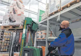  ?? FOTO: MICHAEL HOCHHEUSER ?? Baumarkt-Mitarbeite­r Markus Ferraro befüllt die neu aufgebaute­n Regale mit Waren. In rund zwei Wochen soll der Komplettum­bau abgeschlos­sen sein.