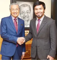  ??  ?? Dr Mahathir (left) shakes hands with Pacquiao during the courtesy call. — Bernama photo