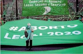  ?? GETTY IMAGES ?? A pro-choice activist applauds in front of a green flag which reads in Spanish ‘‘#Legal Abortion 2020’’ in front of National Congress on November 18, 2020 in Buenos Aires.