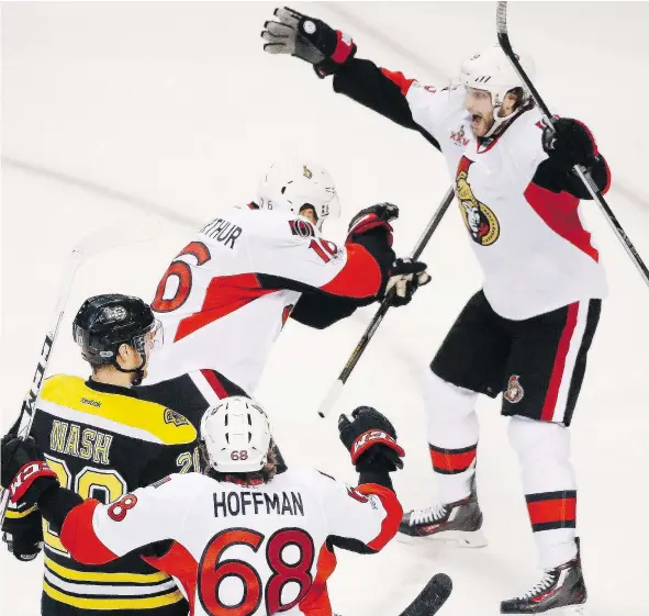  ?? — THE ASSOCIATED PRESS ?? Ottawa Senators’ Clarke MacArthur, top left, celebrates his overtime goal Sunday against the Bruins with teammate Bobby Ryan in Boston. The Senators won 3-2 and now face the New York Rangers to see who will go to the Eastern Conference final.