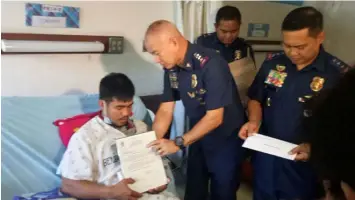  ??  ?? Philippine National Police Chief Oscar Albayalde visits Patrolman Erwin Calixto at the Benguet General Hospital on April 9, 2019. Calixto was wounded in a clash with communist rebels in Mountain Province. (PNP photo)