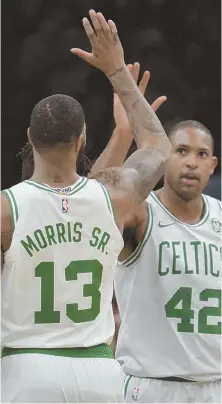  ?? STAFF PHOTOS BY CHRIS CHRISTO ?? GOOD EARLY RETURNS: Jayson Tatum (left) led the Celtics with 23 points in their season-opening 105-87 victory against the 76ers last night at the Garden; at right, Al Horford gets a high five from Marcus Morris.