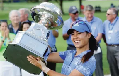  ??  ?? OLYMPIA FIELDS: Danielle Kang raises the championsh­ip trophy after winning the Women’s PGA Championsh­ip golf tournament at Olympia Fields Country Club, Sunday, in Olympia Fields, Ill. —AP