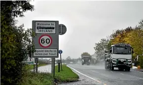  ?? GETTY IMAGES ?? Traffic moves by a defaced ’Welcome to Northern Ireland’ sign on the Irish border as Theresa May’s government owrks to avoid a ‘‘hard’’ border post Brexit.
