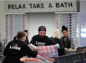  ?? AFP ?? Workers press the ingredient­s into a mold to make bath bombs in the ‘Ballistics Department’ at Lush cosmetic company in Poole, England, on May 10, 2023.