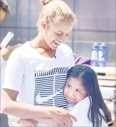  ?? Peter Hvizdak / Hearst Connecticu­t Media ?? Whitney Osuigwe, the No. 1-ranked junior in the world, gets a hug from Katherine Tecante, 9, during the annual Connecticu­t Open Tennis tournament lesson for New Haven youth at the Connecticu­t Tennis Center on Wednesday.