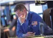  ?? ANDREW BURTON, GETTY IMAGES ?? A trader works on the floor of the New York Stock Exchange on Oct. 14 after bad news from Walmart pushed down the Dow.