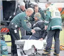  ?? Photo: FAIRFAX NZ ?? Narrow escape: One of two injured climbers, who were swept about 500 metres down Mt Taranaki by an avalanche, is cared for by helicopter crew and paramedics after being rescued yesterday.