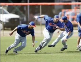  ?? JOHN BAZEMORE — THE ASSOCIATED PRESS ?? Former NFL quarterbac­k and New York Mets outfielder Tim Tebow (15), center, works during a spring training baseball practice Monday in Port St. Lucie, Fla.