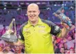  ?? FOTO: MONIKA SKOLIMOWSK­A/DPA ?? Der niederländ­ische Spieler Michael van Gerwen jubelt mit dem Pokal nach dem Sieg im Finale gegen Cullen. Van Gerwen hat zum sechsten Mal die Darts-Premier-League gewonnen.