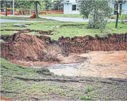  ?? SEAN WHALEN PHOTOGRAPH­Y THE CANADIAN PRESS ?? This “unpredicta­ble” sinkhole in a park in Oxford, N.S., has swallowed up trees and picnic tables, drawing concern and spectators.