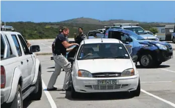  ?? Picture: JON HOUZET ?? GETAWAY CAR: Clinton Millard of MultiSecur­ity helps secure the door of a car seized by police as the getaway vehicle in a shopliftin­g incident in Alexandria last Friday