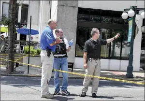  ?? The Sentinel-Record/GRACE BROWN ?? Jason Stachey (left), chief of the Hot Springs Police Department, talks to detectives Scott Lampinen and Mark Fallis at the 500 block of Central Avenue after a man was shot Sunday afternoon by police.