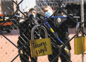  ?? Stephen Maturen / Getty Images ?? Locks with the names of people killed by law enforcemen­t officers hang from fencing outside the Minneapoli­s courthouse where Derek Chauvin is on trial.