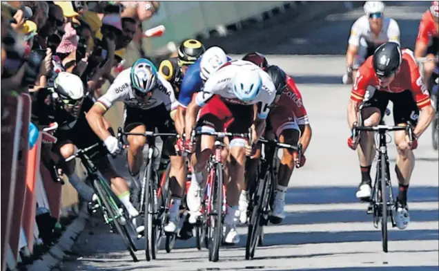  ??  ?? EL GOLPE. En la imagen se puede comprobar cómo Peter Sagan derriba con el codo a Mark Cavendish cuando el británico intenta pasar por las vallas.