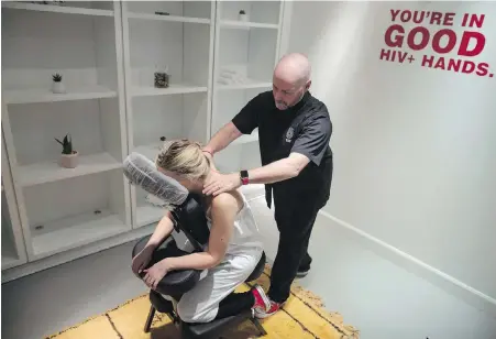  ??  ?? Randy Davis, who is HIV-positive, demonstrat­es a head, neck and shoulder massage on Jackie Kleinberg at Toronto’s Healing House, the world’s first pop-up HIV-positive spa.