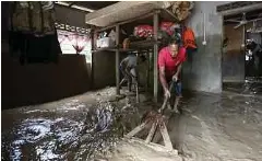  ?? ?? MANGSA banjir, Za’ba Md Alias, 59, (kanan) bersama anaknya, Zulhilmi, 38, membersihk­an lantai rumah mereka yang saluti lumpur ketika tinjauan di Kampung Pasir Raja, Hulu Dungun.