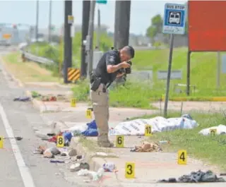  ?? ?? Un agente en la escena donde un coche arrolló a varios inmigrante­s // REUTERS