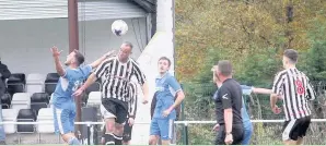  ??  ?? AFC Llwydcoed’s striker Ricky Carter wins this aerial challenge