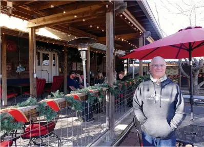  ?? Staff photo by Neil Abeles ?? ■ Lyle McBride, one of the owners of O’Farrell Country Vineyards, is ready to welcome guests to the vineyard’s tasting room open noon to 7 p.m. Fridays and Saturdays. The vineyard’s tasting and dining area is made from the surroundin­gs and the porch of an old barn. The muscadine grapes of O’Farrell Country Vineyards are in their dormant stage right now.