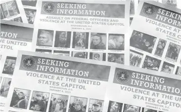  ?? JON ELSWICK/AP ?? The FBI uses flyers to gather tips and track down suspects. More than 700 people have been charged so far.