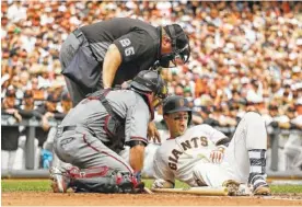  ?? THE ASSOCIATED PRESS ?? The San Francisco Giants’ Buster Posey, right, is looked at by home plate umpire Fieldin Culbreth and Arizona Diamondbac­ks catcher Jeff Mathis after getting hit in the helmet by a fastball thrown by Diamondbac­ks starting pitcher Taijuan Walker in the...