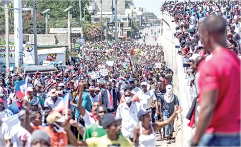  ?? — AFP photo ?? Haitians protesters march through the streets in Port-au-Prince, to denounce the upsurge in kidnapping­s committed by gangs and the inclinatio­ns for a new dictatorsh­ip that the government wants to set up according to them.