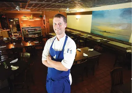  ?? STAFF PHOTO BY TIM BARBER ?? Chef Patrick Halloran stands in the dining room at Hummingbir­d Pastaria on Signal Mountain.