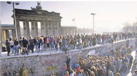  ?? FOTO: IMAGO IMAGES ?? Menschenma­ssen auf und vor der Berliner Mauer am Brandenbur­ger Tor während der friedliche­n Revolution in der DDR.