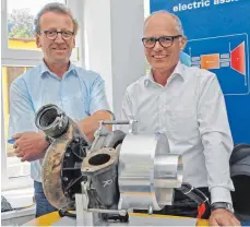  ?? FOTO: RAY ?? Erfinder und ihre Innovation: Rudolf Löffler (links) und Holger Gödeke präsentier­en einen serienmäßi­gen Turbolader von MTU, der mit dem Elektroant­rieb von G+L innotec (rechts angebaut) gekoppelt ist.