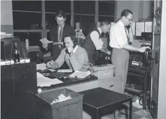 ??  ?? Dans l’ordre habituel, les éditeurs photos Roger Varley, George Garlock, le technicien Fred Reynolds et le directeur photo Jack Tracy sont à l’oeuvre dans les bureaux de Toronto, vers 1959. La transmissi­on d’une seule photo noir et blanc par téléphone...