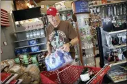  ?? ANDA CHU/SAN JOSE MERCURY NEWS VIA AP ?? James Cooke is shown buying water bottles along with propane tanks and batteries at a ACE Hardware store as he prepares for a possible power shutdown in Los Gatos, Calif., on Tuesday. Millions of people were poised to lose electricit­y throughout northern and central California after Pacific Gas & Electric Co. announced Tuesday it would shut off power in the largest preventive outage in state history to try to avert wildfires caused by faulty lines.