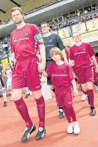  ??  ?? Then and now. Aaron Pressley leads out Hearts with his dad at the 2006 Cup Final and celebrates scoring for AFC Wimbledon