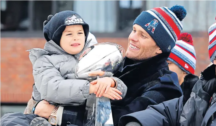  ??  ?? Patriots quarterbac­k Tom Brady and his son Benjamin with Vince Lombardi Trophy during a parade in Boston.