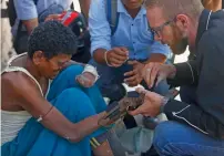  ?? AFP ?? Disaster Hack founder Matthew Rockwell attaching a 3D printed prosthetic hand to leprosy sufferer Ram’s arm in Kathmandu. —