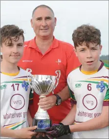  ??  ?? Alan Smith, Chairman, Louth Minor Board presents the Division 2A trophy to Daniel Clinton and Sam Shearman, joint captains, Stabannon/O’Connells/John Mitchels.