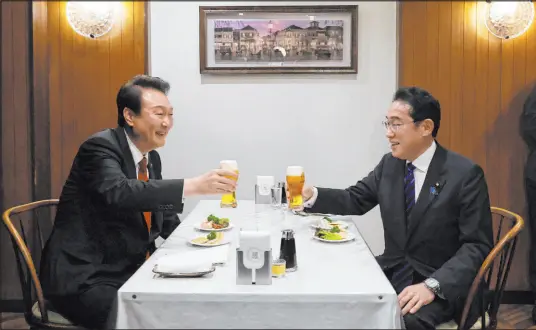  ?? Cabinet Public Affairs Office ?? South Korea’s Yoon Suk Yeol, left, and Japan’s Fumio Kishida make a toast on Thursday at a restaurant in Tokyo.