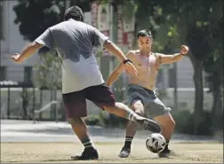  ?? Christina House Los Angeles Times ?? DAVID ORANTES, left, and Julio Ruiz play soccer at Grand Park downtown. A heat advisory is in effect through Monday for most of L.A. County.