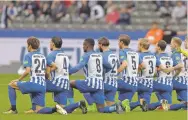  ?? MICHAEL SOHN/THE ASSOCIATED PRESS ?? Hertha Berlin players kneel prior to the match Saturday in Berlin, Germany. The team nodded to social struggles in the United States.