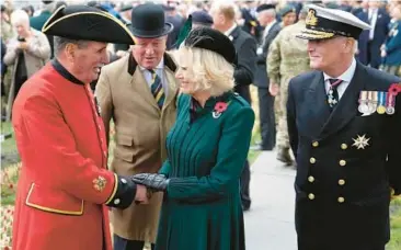  ?? FRANK AUGSTEIN/AP ?? Britain’s Camilla, the queen consort, chats with a Chelsea Pensioner as she meets veterans and members of the armed services at the 94th Field of Remembranc­e service Thursday at Westminste­r Abbey in London. She wore a red poppy pin. The poppy commemorat­es those who died while serving in the military. Pin sales help raise money for veterans.