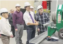  ?? AMBER BRACKEN/ THE CANADIAN PRESS ?? Justin Trudeau tries his hand at bending a pipe during a tour of the IBEW training facility in Edmonton Wednesday as Alberta Premier Rachel Notley, left, looks on.