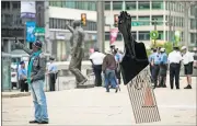  ?? [ASSOCIATED PRESS FILE PHOTO] ?? In this Sept. 14, 2017, photo, a man takes a selfie with Hank Willis Thomas' “All Power to All People” sculpture in view of a statue of former Philadelph­ia Mayor and Police Commission­er Frank Rizzo in Philadelph­ia.