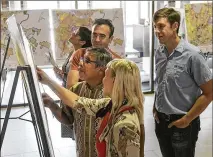  ??  ?? Austin City Council Member Sabino “Pio” Renteria (center) goes over maps of District 3 with some of his constituen­ts during an open house for CodeNext, the city’s massive land-use rewrite, in the lobby of Austin City Hall last month.