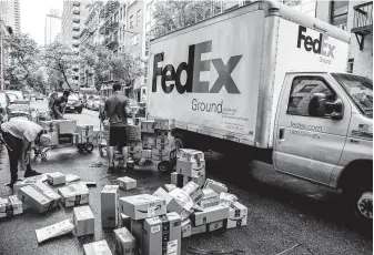  ?? Brittainy Newman / New York Times file ?? A FedEx truck drives around workers sorting packages in Manhattan. FedEx ended its 2018 fiscal year having spent $240 million less on capital investment­s than it predicted it would in 2017.