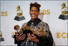  ?? (AP Photo/John Locher) ?? Jon Batiste, winner of the awards for best American roots performanc­e for “Cry,” best American roots song for “Cry,” best music video for “Freedom,” best score soundtrack for visual media for “Soul,” and album of the year for “We Are,” poses with his trophy haul backstage at the Grammy Awards on April 3.