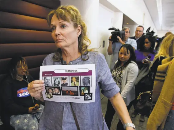  ?? Rich Pedroncell­i / Associated Press ?? Melanie Barbeau displays photos of people believed to have been slain by the Golden State Killer as she leaves a hearing for suspect Joseph DeAngelo in May.