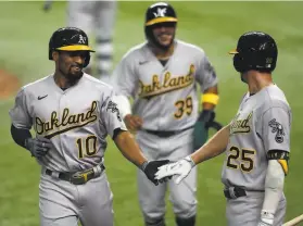  ?? Ronald Martinez / Getty Images ?? A’s shortstop Marcus Semien (10) celebrates a threerun home run with Stephen Piscotty (25) against the Texas Rangers in the fifth inning of Saturday’s nightcap at Globe Life Field in Arlington, Texas. Semien also had an RBI single in the A’s sevenrun second inning.