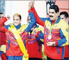  ??  ?? Venezuelan President Nicolas Maduro (right), raises Venezuelan Bronze medallist boxer Yoel Segundo Finol’s arm (left), during the welcome ceremony of Venezuelan athletes who participat­ed in the Rio 2016 Olympic Games, at the
Miraflores Presidenti­al...