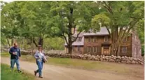  ??  ?? Visitors walk past Hartwell Tavern on the restored Battle Road at Minute Man National Historical Park in Lincoln, Mass.